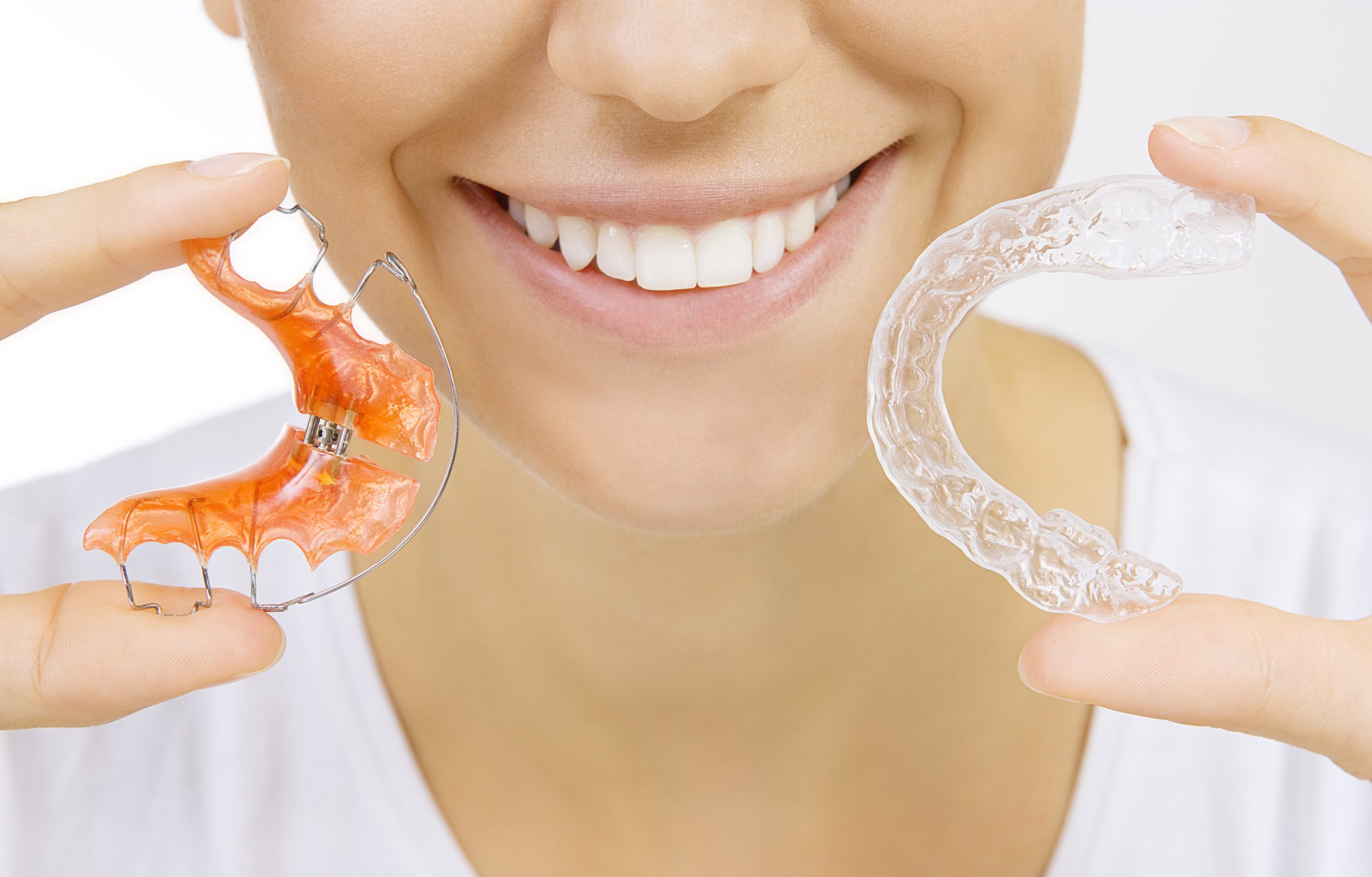 A girl holding dental Retainers